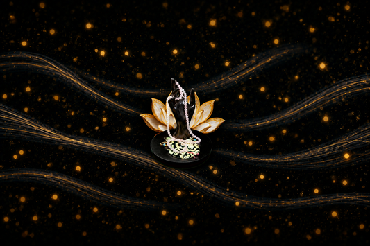 Mala prayer beads on a dark display with a gold lotus backdrop, centered with generous background space for blog-card cropping.