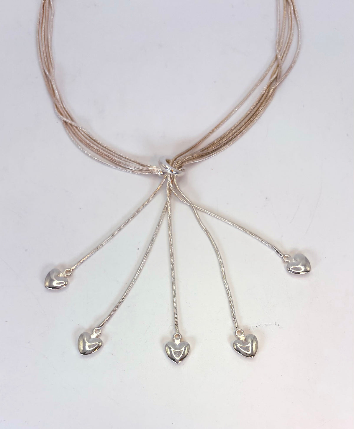 Five-heart necklace detail with polished heart drops