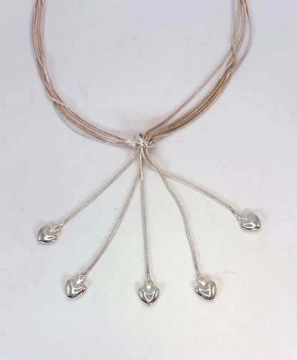 Five-heart necklace detail with polished heart drops