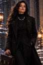 Mannequin wearing a black leather jacket and black sweater with a colorful necklace against a blue wall.