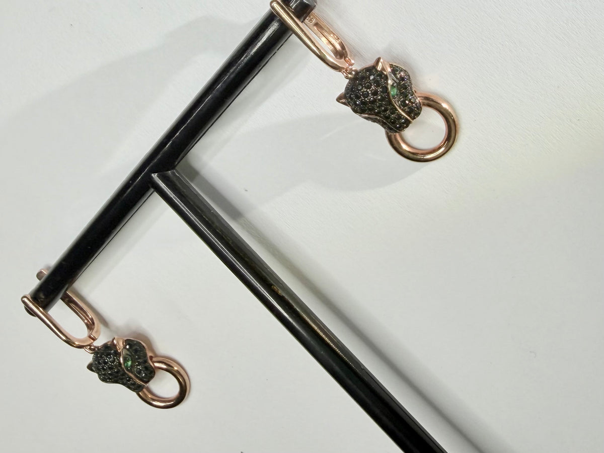 Original photo of dark cat-head drop earring with round lower ring