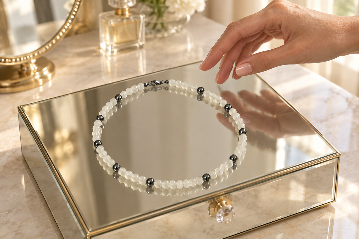 Your necklace on a mirrored jewelry box atop a luxurious dressing table, with a hand reaching toward it